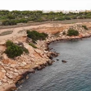 Kustlijn met rotsen en strand bij Punta Prima